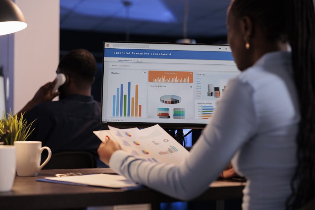 young businesswoman working with statistics charts on computer monitor
